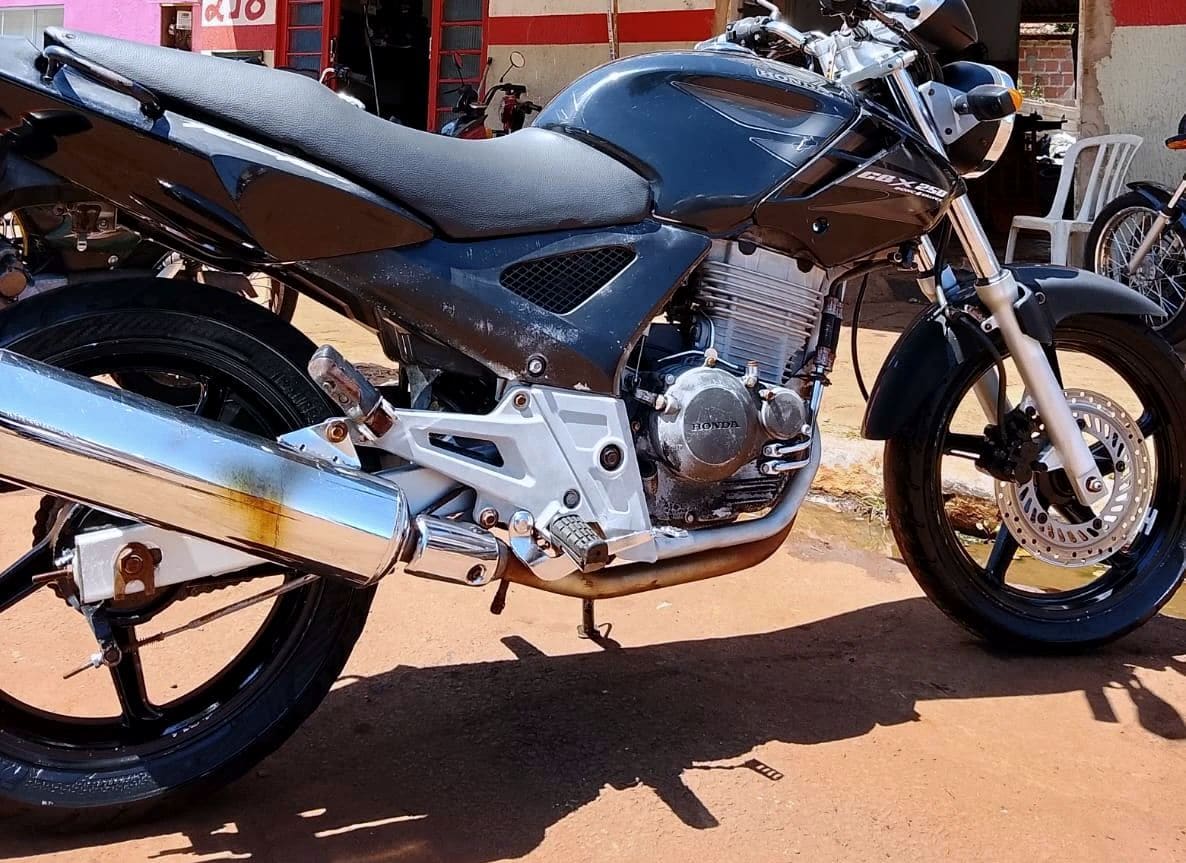 Honda CBX preta estacionada em frente à oficina