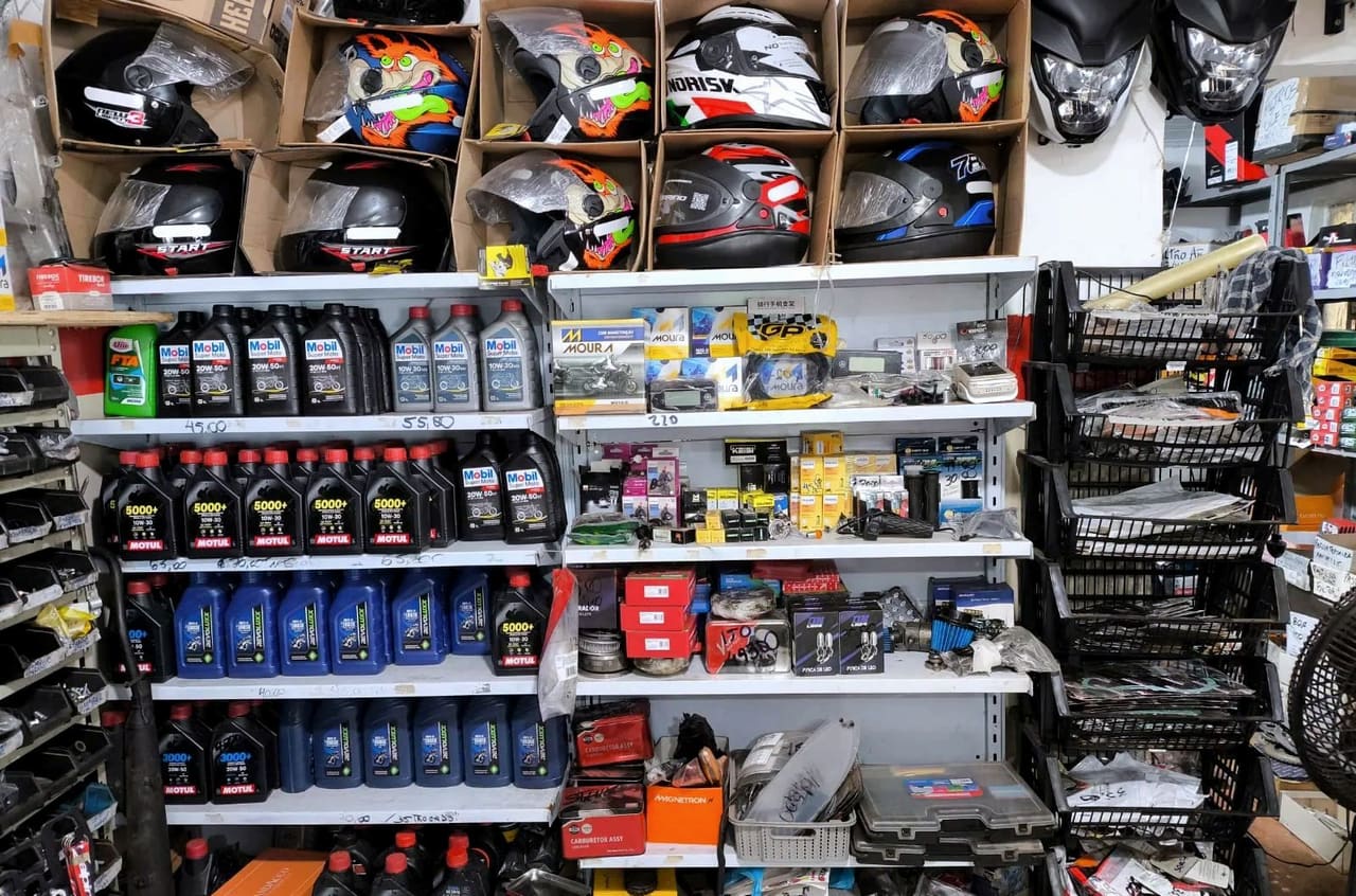 Loja de peças com capacetes, óleos e baterias nas prateleiras