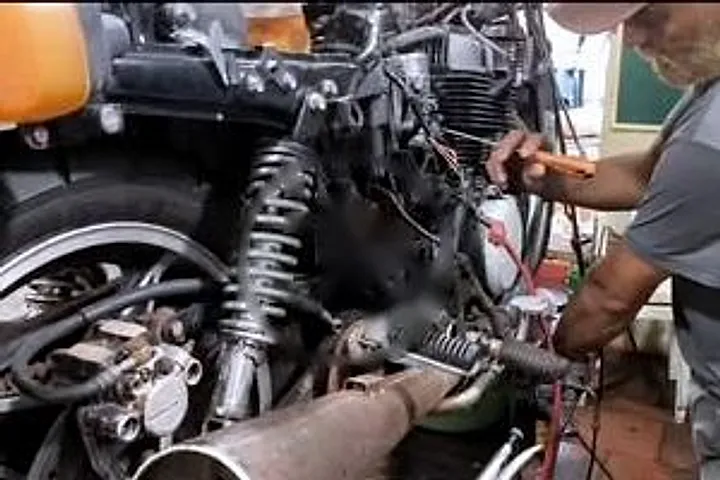 Mecânico trabalhando no motor de uma Honda CB 450 DX